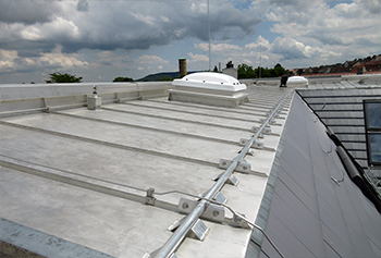 Metal roofing out of Uginox with ridge ventilation, a snow guard system and the integration of light domes