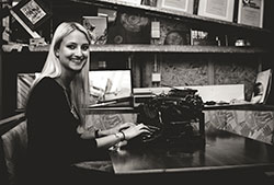 In the museum, granddaughter is trying to type on an antiqued typewriter